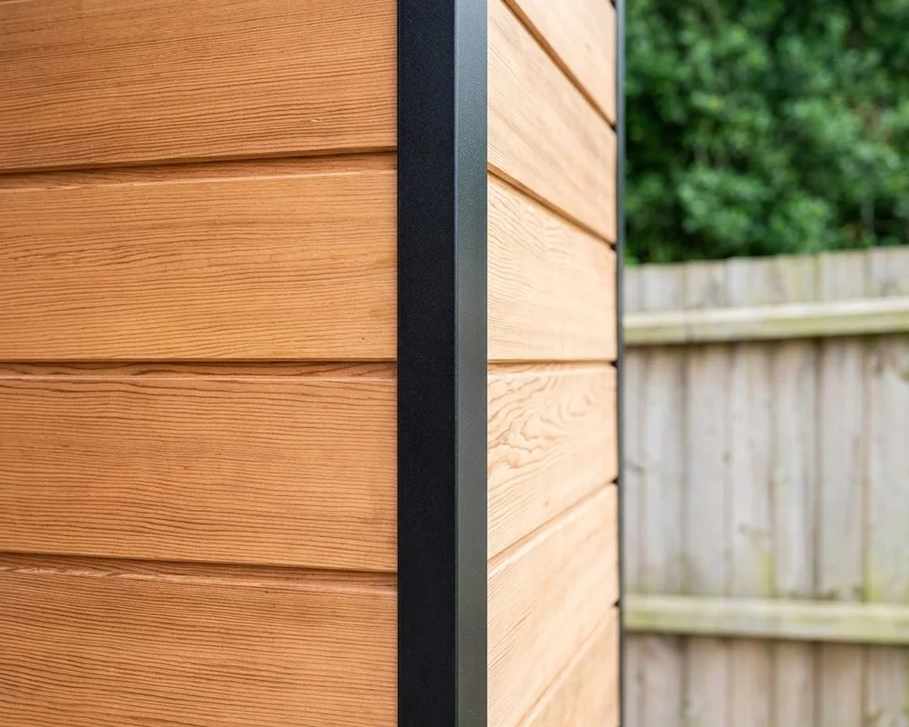 Detail of garden room construction showing aluminium frame meeting Western Red Cedar cladding